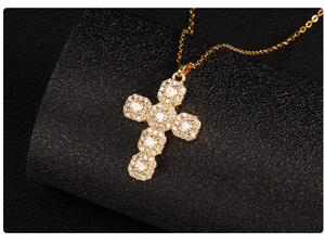 Macro view of gold cross pendant necklace featuring micro-paved sparkling cubic zirconia