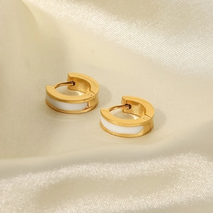 Détail de boucles d'oreilles créoles en acier titane doré 18K et émail blanc sur soie