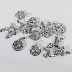 Vue détaillée de pendentifs en acier poli argenté aux motifs d'ange et de cœur