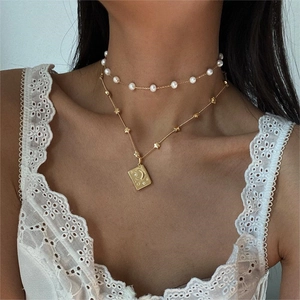 Double-layered gold necklace with pearl choker and engraved star moon pendant