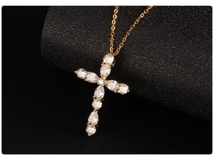 Detailed macro view of gold cross pendant with micro-pave cubic zirconia on black background