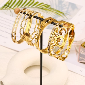 Set di cinque braccialetti dorati con zirconi e design a foglia su supporto nero