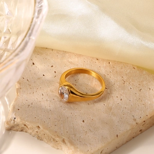 Macro detail of 18K gold stainless steel ring featuring a green oval-cut zircon stone