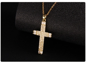Macro shot of gold cross pendant with micro-pave zircons and baguette-cut stones