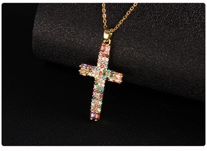 Detail of gold cross necklace with colorful micro-pave cubic zirconia on black stand