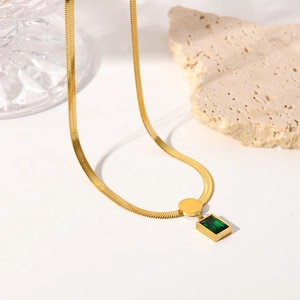 Detail of 18K gold-plated snake chain necklace with rectangular emerald green gemstone
