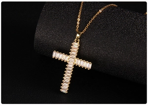 Detailed close-up of gold cross pendant with micro-pave cubic zirconia on black leather