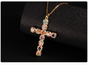 Macro shot of gold-plated cross pendant with vibrant micro-set colorful zircons