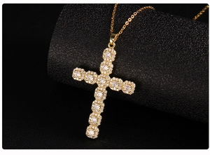 Macro shot of gold cross pendant with micro-pave cubic zirconia on black texture
