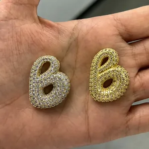 Comparaison de pendentifs lettre B dorés avec pavage complet et partiel de zircons