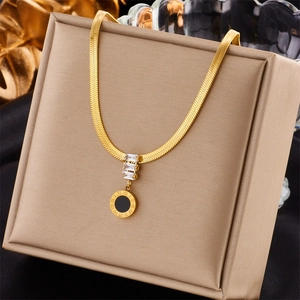 Detail of gold snake chain necklace with Roman numeral pendant and zircon accents