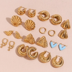 Mise à plat de boucles d'oreilles vintage dorées et parures de bijoux en coquillage