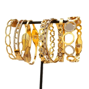 Set di bracciali in acciaio dorato con foglie traforate, cuori e dettagli in cristallo