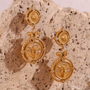 Macro detail van vintage gouden hart oorbellen met engel munt en fonkelende strass