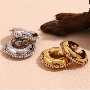 Vue détaillée des boucles d'oreilles épaisses en forme de C avec cristaux en or et argent