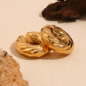 Vue macro détaillée des boucles d'oreilles créoles torsadées en acier plaqué or 18K