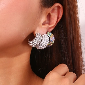 Close-up of 18K gold plated C-shaped earrings with pearls, white crystals and colorful stones