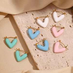 Détail des boucles d'oreilles en forme de cœur dorées avec revêtement en émail coloré