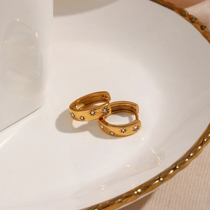 Detailed macro view of 18K gold plated hoop earrings with sunburst zircon engravings