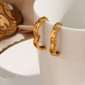 Detailed view of 18K gold plated hoop earrings with sunstar carvings and zircons