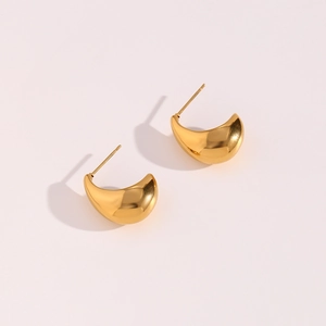 Détail des boucles d'oreilles dorées forme bateau avec finition métallique brillante