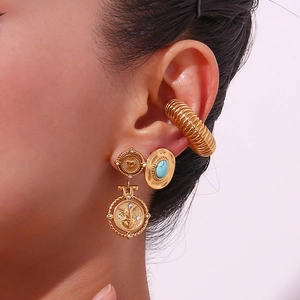 Detailopname van vintage 18K gouden oorbellen met turkoois en engelreliëfhangers