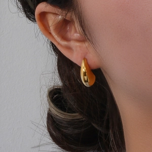 Boucles d'oreilles gouttes dorées polies en forme de bateau portées par un mannequin