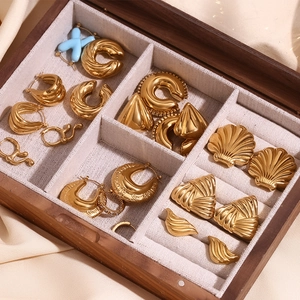 Collection de boucles d'oreilles en acier inoxydable doré 18K dans une boîte à bijoux
