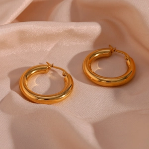 Dettaglio di spessi orecchini a cerchio in acciaio inossidabile placcati oro 18K su raso