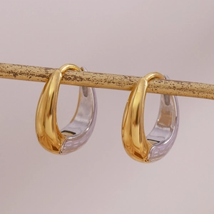 Makroaufnahme von zweifarbigen, gold-silbernen Creolen in Birnenform an einem Stab