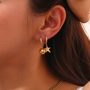 Dettaglio di orecchini asimmetrici placcati oro 18K con pavé di zirconi e stella