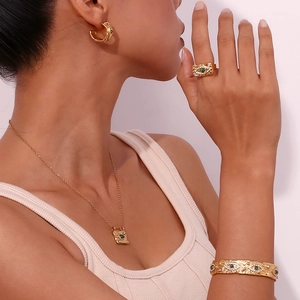 Set gioielli dorati con ciondoli occhio in malachite su modella per un look di lusso