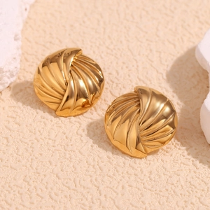 Détail de boucles d'oreilles coquillage dorées 18K avec textures en spirale polies