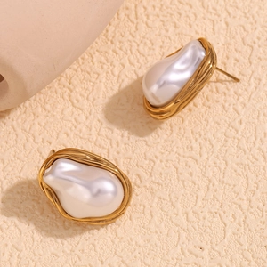 Macro detail of French vintage baroque pearl earrings with textured gold lava metal rim