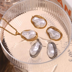 Baroque irregular pearls in gold-plated settings on textured glass background