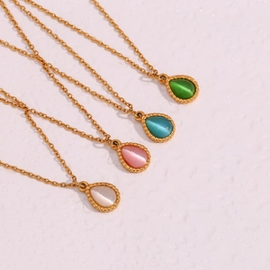 Detalle de cuatro colgantes de gota con piedras de ojo de gato y bordes dorados