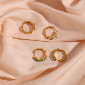 Detail of geometric hexagonal earrings with green and clear cubic zirconia on silk