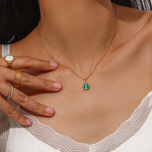 Detalle de collar con opalo de gota y anillos dorados con elegante encaje blanco