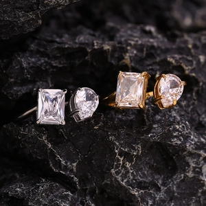 Close-up of teardrop and emerald cut zircon stones on adjustable 18K gold plated rings
