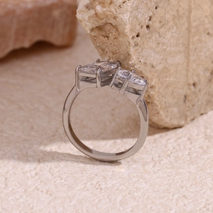 Close-up of a silver ring featuring pear and rectangular cubic zirconia on a stone base