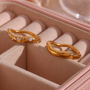 Close-up of gold plated wave rings with micro-inlaid zircon in pink velvet box
