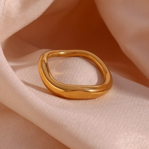 Macro shot of 18K gold plated irregular wave ring on champagne silk background