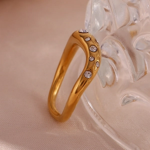 Macro detail of 18K gold plated irregular wavy ring with micro-set zircons on silk
