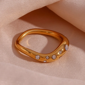 Macro detail of an 18K gold plated irregular wave ring with micro-inset zircons