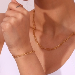 Detail van de 18K vergulde paperclip ketting en armband gedragen door een model