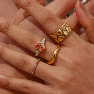 Detail shot of 18K gold plated stacked rings with orange gemstone and pave heart design
