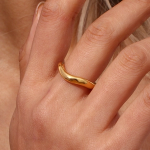 Macro view of 18K gold plated wavy ring showing polished curves and metallic luster