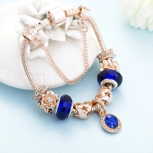 Elegante bracciale in oro rosa con ciondoli in cristallo blu e charms a stella