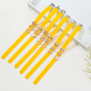Set of seven yellow adjustable 10mm silicone bracelets with various charms and buckles