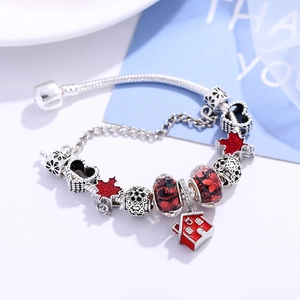 Silver snake chain bracelet featuring red maple leaf and house charms with glass beads